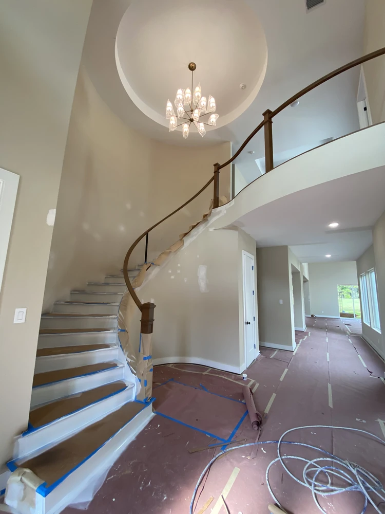 Freshly painted two-story entryway with a curved staircase in The Woodlands, TX